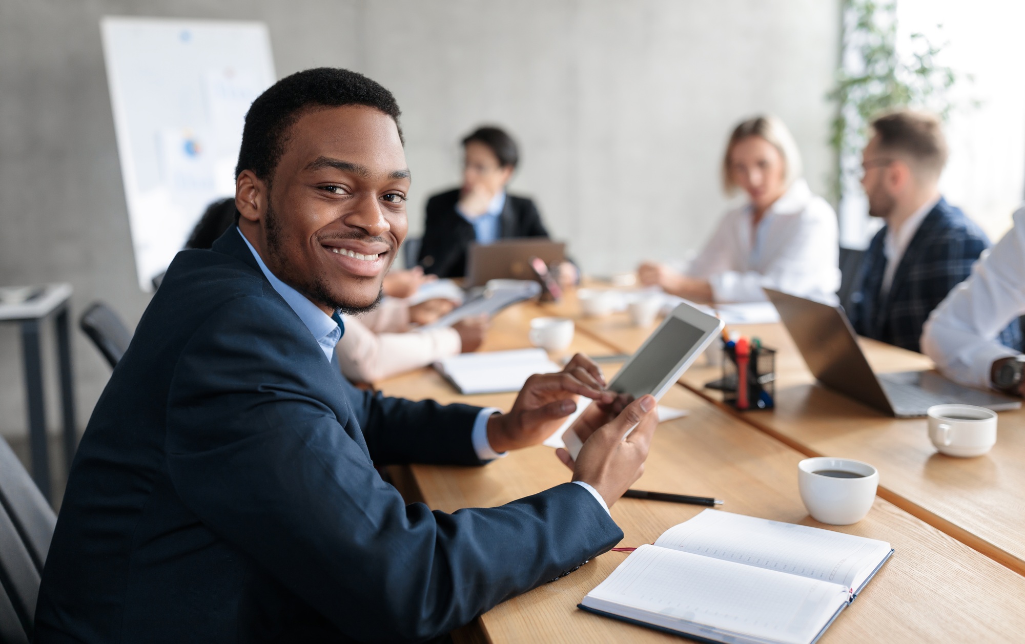 African Businessman Using Digital Tablet At Corporate Meeting In Office